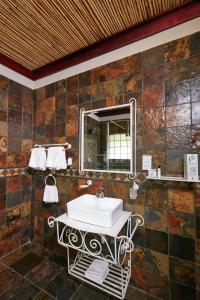 哈博罗内Manong Game Lodge的一间带水槽和镜子的浴室