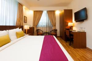 新德里FabHotel Goodwill GK 1的酒店客房设有一张大床和一张书桌。