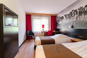 吕伐登巴斯通吕伐登酒店的酒店客房配有两张床和一张书桌