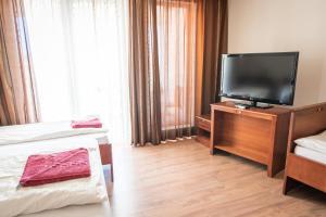 包姚Kaiser Residence的酒店客房设有两张床和一台平面电视。