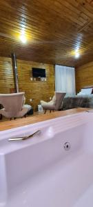 乌鲁比西Hospedaria Kayser Haus的浴缸,室内配有两把椅子