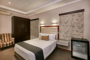 哈博罗内Regent Kgale Lodge的一间酒店客房,配有一张床和一台电视