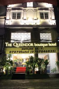 胡志明市THE QUEENDOR BOUTIQUE HOTEL的一座建筑,上面有标志,上面有俯瞰着精品酒店的标志