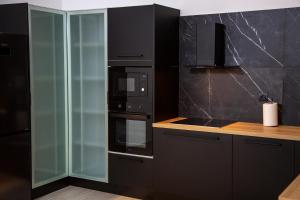 普雷韦扎Elea resort的厨房配有黑色家电和玻璃橱柜
