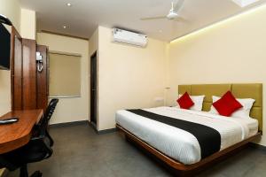 MohammadnagarSuper Capital O Hotel Siddartha Grand的酒店客房配有一张床、一张书桌和一张书桌。