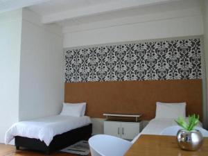 克尼斯纳克尼斯纳宾馆的一间设有两张床、一张桌子和一面墙的房间