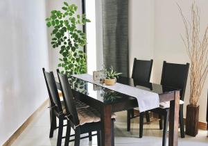胡鲁马累BODU ASHI MALDIVES - Central 3 Bedroom Apartment的用餐室配有带黑色椅子的桌子