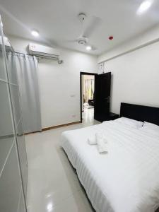 胡鲁马累BODU ASHI MALDIVES - Central 3 Bedroom Apartment的卧室配有白色的床和玻璃墙