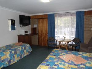 维克多港冬日阳光汽车旅馆的酒店客房设有两张床和一张桌子。