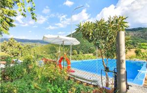 奥尔戈索洛Amazing Home In Orgosolo With House A Mountain View的游泳池旁配有遮阳伞