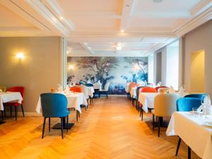 奥登塔尔Romantikhotel Altenberger Hof的用餐室配有白色的桌子和蓝色的椅子