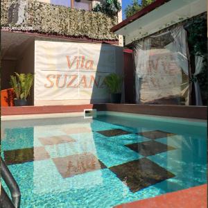维纳斯Vila Suzana的一座游泳池,在建筑物的一侧有标志