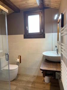 伊萨瓦Casa rural ELURKOIA的一间带水槽和卫生间的浴室以及窗户。