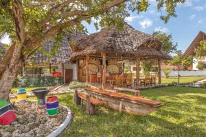 吉汶瓦吉汶瓦海滩度假酒店的庭院中带木船的木制凉亭