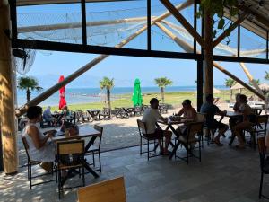 Grilë斯库台湖度假酒店的一群坐在海滩桌子上的人