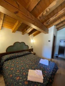 平佐洛Hotel Quadrifoglio的一间带一张床的卧室,位于带木制天花板的房间内