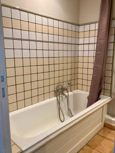 格里莫Les Restanques 3120 vue mer 3 chambres的带浴缸的浴室和瓷砖墙
