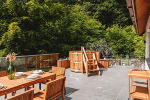 安布尔塞德Loughrigg Cottage的庭院设有木桌、椅子和树木