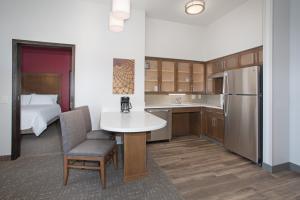 拉皮德城Staybridge Suites Rapid City - Rushmore, an IHG Hotel的一间厨房,内设一张桌子和一张床