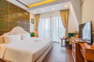 芽庄Boutik Cham NhaTrang Hotel的一间卧室配有一张床、一张书桌和一台电视