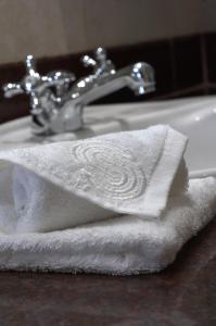 Kigo维多利亚湖塞雷娜高尔夫度假酒店及Spa的浴室水槽上方的白色毛巾