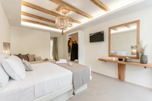 纳克索乔拉Heavenly Suites & Studios的白色卧室设有一张大床和镜子