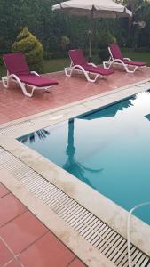 亚历山大Relaxation Villa with private pool的一个带两把椅子和遮阳伞的游泳池