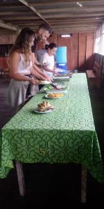 伊基托斯Golden waters Lodges的一群人站在长桌旁,一边吃盘子