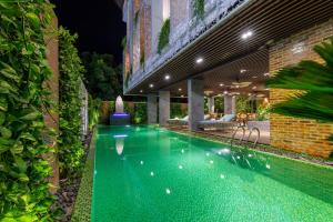 芽庄Boutik Cham NhaTrang Hotel的夜间在院子中间的游泳池