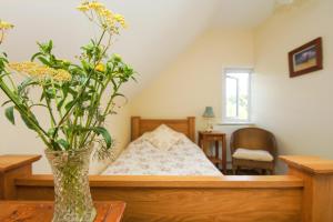 HandcrossBeeches Cottage - Beautiful Garden - Parking的卧室里一个花瓶,桌子上放着鲜花