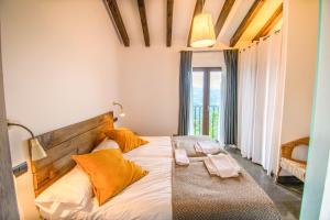 ZigaBehin Batean, espectacular casa rural en pleno corazón del valle Baztán的一间卧室配有一张带橙色枕头的大床