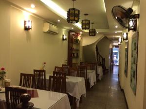 河内Hanoi Charming House的用餐室配有桌椅和灯光