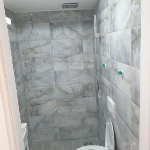 贝尔格莱德Gas Otel的一间带卫生间和大理石墙的浴室