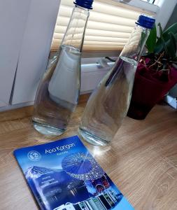 皮特什蒂Apartament Marasesti的2瓶水和一张桌子上的书