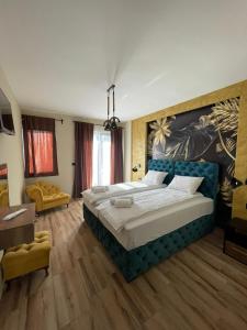 大格拉迪什泰ATOS Srebrno jezero - Villa and Restaurant的卧室配有一张大床,墙上挂有绘画作品