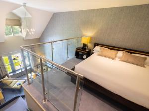 奥赫里姆玛克雷丁村布鲁克小屋酒店的一间卧室设有一张床和一个玻璃楼梯