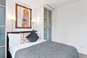 伦敦Modern 2 Bedroom Apartment in Hoxton的一间卧室配有一张床和镜子