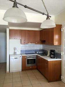 LilikásKomiVillas的厨房配有棕色橱柜、白色家电和2盏灯