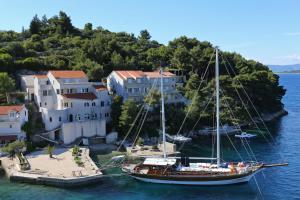 拉茨斯切Apartments by the sea Racisce, Korcula - 151的船停靠在房子旁边的水中