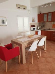 拉茨斯切Apartments by the sea Racisce, Korcula - 151的厨房配有木桌和白色椅子