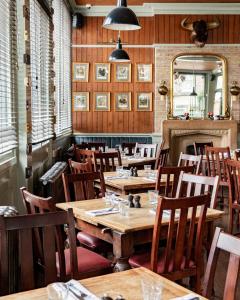 伦敦The Bull & Last的餐厅设有木桌、椅子和镜子