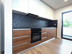 克卢日-纳波卡Ira Premium Apartment Cluj的厨房配有白色橱柜和黑烤箱。