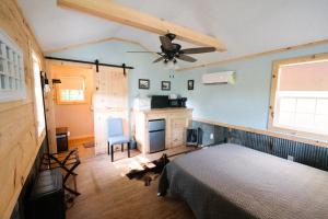 Grand RiversThe Outpost的一间卧室配有一张床和吊扇