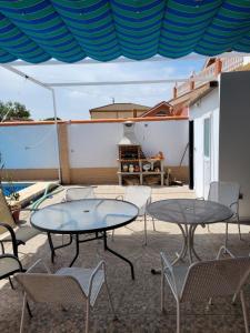 巴伦西纳德拉孔塞普西翁Casa cerca de Sevilla con piscina的庭院配有2张桌子和椅子以及桌子。