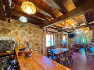Montejo de la Vega de la SerrezuelaHOTEL RURAL LA HUERTA的厨房以及带木桌和椅子的用餐室。