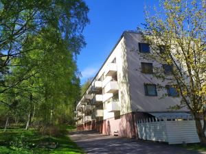 赫尔辛基Ihan Puotilan Metron lähellä的前面有树木的白色大建筑