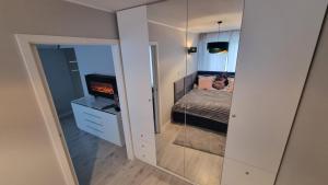 雅罗斯瓦夫Apartament ZACISZE的一间小卧室,配有一张床和镜子