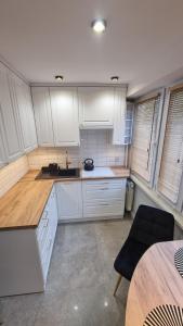 雅罗斯瓦夫Apartament ZACISZE的厨房配有白色橱柜和木制台面