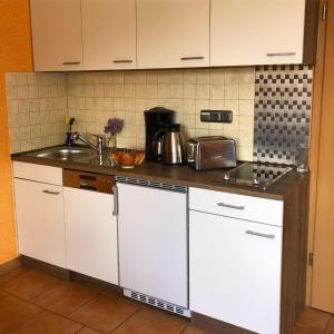 宾茨Ferienhaus-Binz的厨房配有白色橱柜和水槽