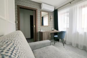 利托米什尔金星酒店的一间带沙发、书桌和镜子的卧室